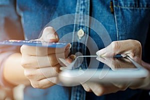 Finger of woman hand with jean shirt holding mobile phone and credit card to shopping online buy product in the website