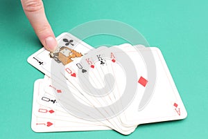 Finger of woman pulling game card from stack of cards