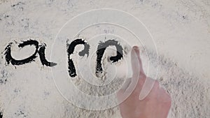 Finger write APPLE on a white flour background. top view 4k