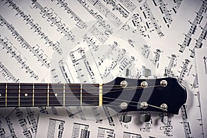 Fingerboard acoustic guitar on a background sheet notes