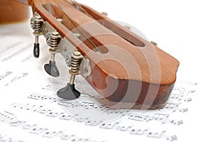 Fingerboard of old guitar under leaf with notes