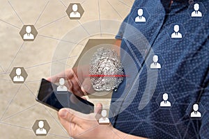 Fingerprint scanning on the touch screen with a blur background of the businessman with the phone.The concept of Secure access thr