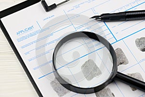 Fingerprints card police form on A4 tablet lies on office table with pen and magnifying glass