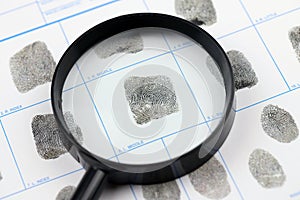 Fingerprints card police form on A4 tablet lies on office table with pen and magnifying glass