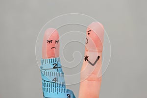 Fingers art of couple with meter. Concept husband is angry that his wife can not lose weight