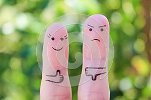 Fingers art of couple. Woman showing thumbs up and man showing thumbs down. Concept of disagreement in family