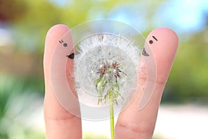 Fingers art of happy couple. Man is giving flowers to woman