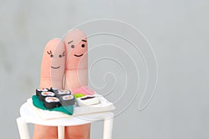 Fingers art of Happy couple. Man and woman eat sushi in cafe