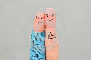 Fingers art of a Happy couple with tape measure. Concept of losing weight together