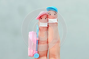 Fingers art of happy family with face mask. Man and woman going on vacation