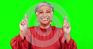 Fingers crossed, happy and portrait of a woman on green screen for hope, good luck or wish. Mature female or excited