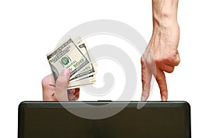 Fingers going the laptop to the hand holding dollars