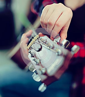 Fingers holding guitar pegs