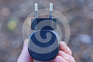 fingers holding one black electrical socket on a flashlight