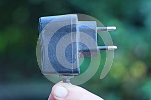 fingers holding one black electrical socket on a flashlight