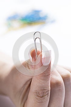 Fingers holding a paper clip