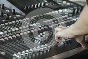 Fingers move the sliders on the big sound mixer 3