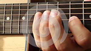 Fingers of a musician on guitar fretboard closeup