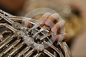 The fingers of the musician playing the French horn