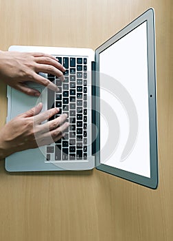 Fingers operating keyboard of a laptop view from top with ad space on laptop screen