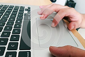 Fingers operating touchpad of a laptop