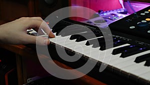 Fingers playing electric piano in home recording studio. Hands creating and recording song in music studio, close up. Music compos