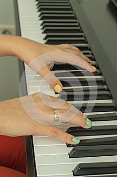 Fingers playing electronic piano keyboards