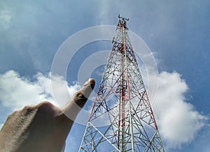 Fingers pointing to telecommunication tower