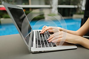 Fingers typing on computer keyboard sunny day