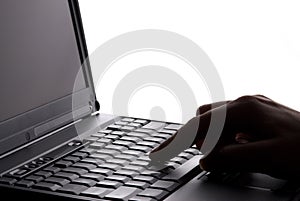 Fingers typing on laptop keyboard