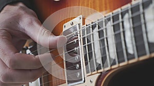 Fingerstyle guitar player practicing song on guitar. Hands picking and pulling guitar strings. Close up view. Music concept