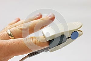 Fingertip pulse oximeter sensor placed on finger photo