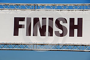 A finish line banner isolated across a clear blue sky