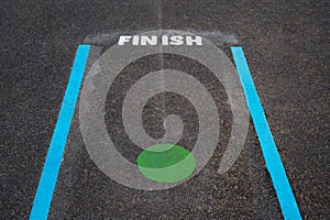 Finish line and Green spot on tarmac floor in School playground,Blue line and Green Circle with Finish word on pavement at public