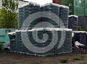 Finished products of clean bottles are packed in pallets. Racks with bottles are in  abandoned area near  glass factory near