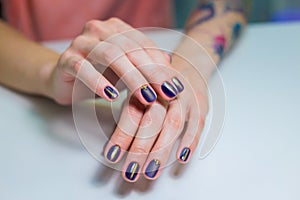 Finished purple shellac manicure, woman in nail beauty salon. photo