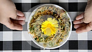 The finished salad in the plate turns clockwise, then the hands lift it up, thereby blurring the background