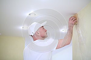 Finisher polishing the wall near the ceiling using