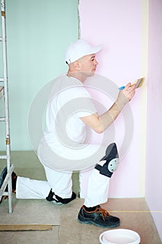 Finisher in white clothes painted walls in pink