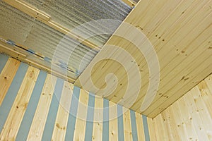 Finishing of the ceiling insulated with foamed polyethylene with wooden clapboard during the construction of a country house