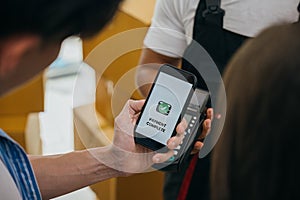 After finishing the move couple pays using smartphone QR code. Worker holds box