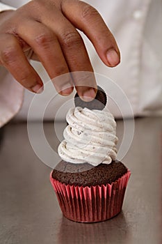 Finishing touches on cookies and cream cupcake
