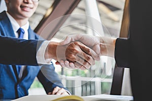 Finishing up a meeting, handshake of two happy business people after contract agreement to become a partner, collaborative