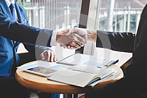 Finishing up a meeting, handshake of two happy business people after contract agreement to become a partner, collaborative