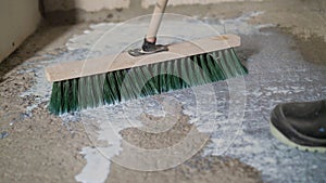 Finishing work - applying a primer or varnish to a concrete surface. The brush cleans the floor before repair. Apply the