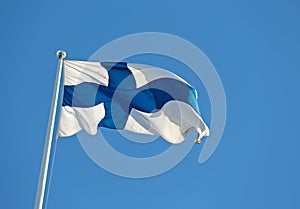 Finlands blue and white flag waving against blue sky