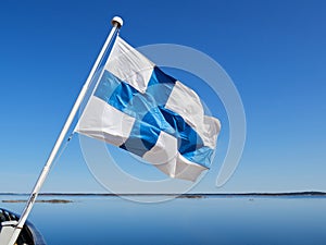 Finnish flag, archipelago panorama, sea, islands, blue sky.
