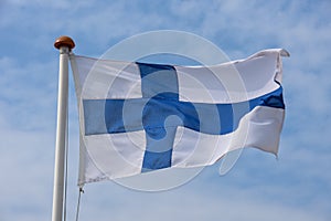 Finnish flag waving against blue sky