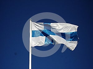 Finnish flag waving in the wind in front of a blue sky