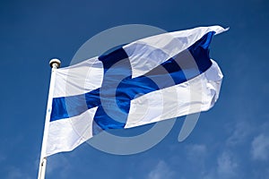 Finnish national flag on the wind against the blue sky photo